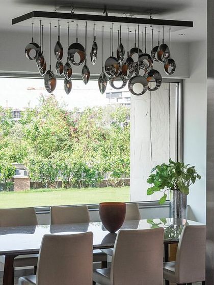 The directors' dining room overlooks the terrace, featuring a contemporary dining set and a striking decorative chandelier, perfect for formal meetings or private meals.