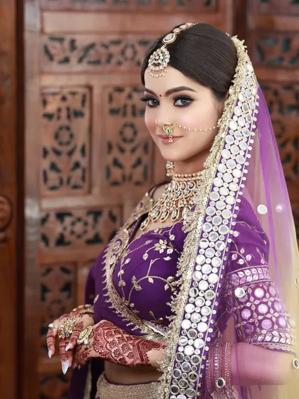 I love working with unconventional colors. For this bride, we chose a striking purple lehenga and created a soft glam makeup look with defined eyes and a nude lip to balance the vibrant outfit.