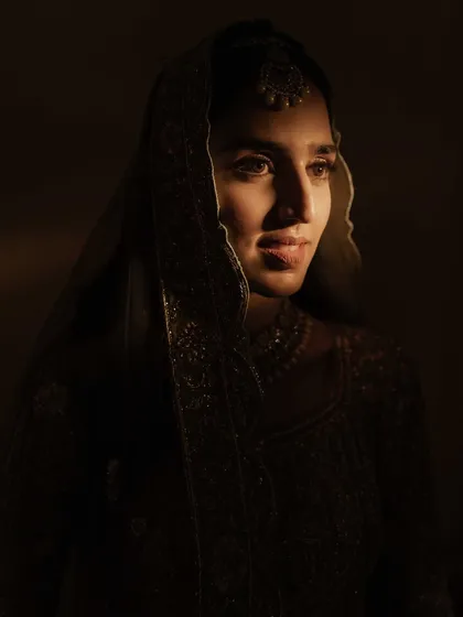 A close-up portrait with dramatic side lighting. This artistic shot highlights the bride's features and creates a contemplative, soulful mood.