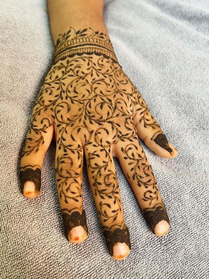 A clear shot of the leafy vine pattern on the child's palm.