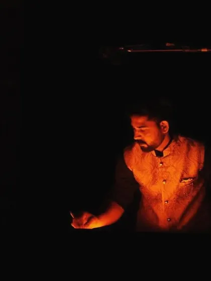 A dramatic shot of me at my light box, with the warm glow illuminating the sand in my hand. This image captures the intimate and focused connection between the artist and his medium.
