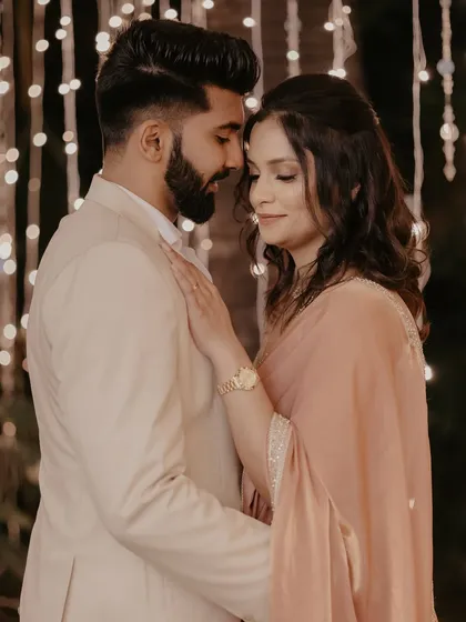 An intimate and romantic pose, with the couple lost in their own world against a curtain of sparkling lights.