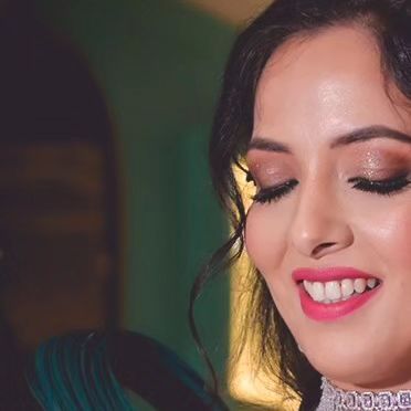A candid, happy moment from an engagement party. The makeup features a bright pink lip and shimmery eyes, a perfect combination for a night of celebration.