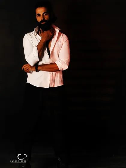 Using negative space to create a dramatic, low-key male portrait. The single light source carves him out of the darkness, emphasizing form and a brooding intensity.