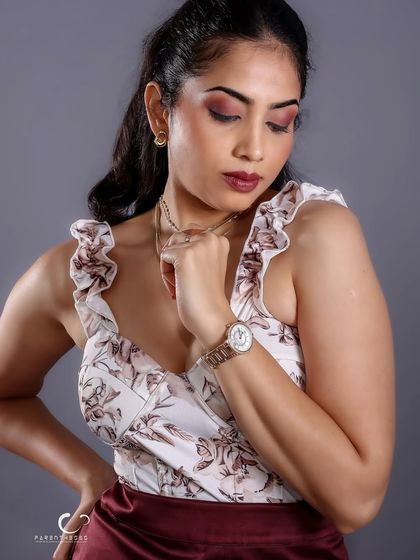 An elegant, downward glance. This pose, combined with the soft studio lighting, creates a classic and sophisticated portrait that feels both personal and timeless.