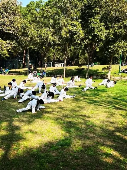 More of our students working on their flexibility during the belt test at Nehru Park. We take advantage of open spaces for large group training.