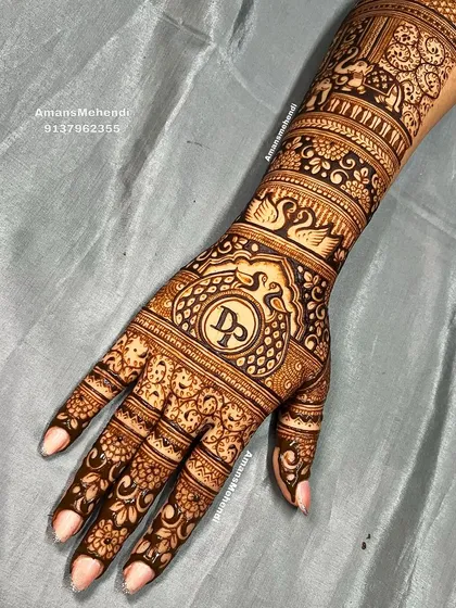 A personalized back-hand bridal design with the initials 'D' and 'P' at the center, surrounded by swans and floral bands.