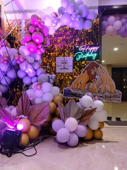 A Lion King "Simba" themed birthday entrance, featuring a gold shimmer wall, a purple and gold balloon arrangement, and a character cutout.