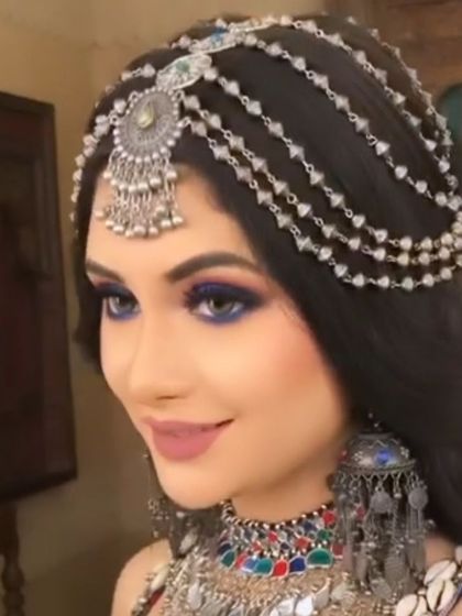 A model showing off a beautiful oxidised silver mathapatti with multiple chains. This hair accessory is perfect for a festive or bohemian look.