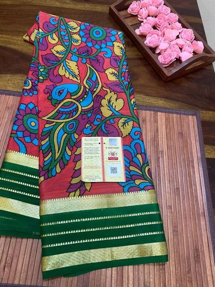 A vibrant red peacock Kalamkari print on a Mysore silk saree with a green border.