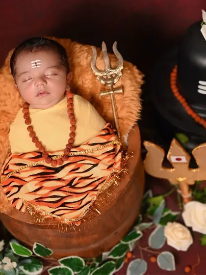 A newborn Bala Shiva setup with all the traditional elements like the Trishul and Rudraksha beads.