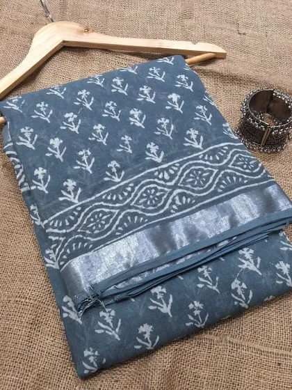 A beautiful grey-blue cotton linen saree with a delicate white handblock print. Paired with a silver oxidized bracelet, it creates a perfect ethnic-chic look.
