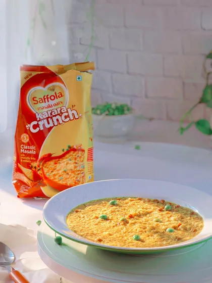 A bright and airy lifestyle shot of Saffola Masala Oats, prepared in a bowl to look like a delicious and healthy meal.