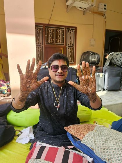 This groom is all smiles showing off his wedding mehndi. We incorporated figures and symbols that were important to him, creating a design that was both traditional and deeply personal.