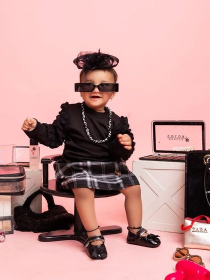 Putting on her cool shades, this shot is full of personality. The pink background adds a fun, vibrant touch to this fashion-themed shoot.