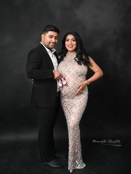 Ready for their new arrival. This couple's portrait includes a pair of tiny baby shoes, a sweet symbol of the little one they are eagerly awaiting.
