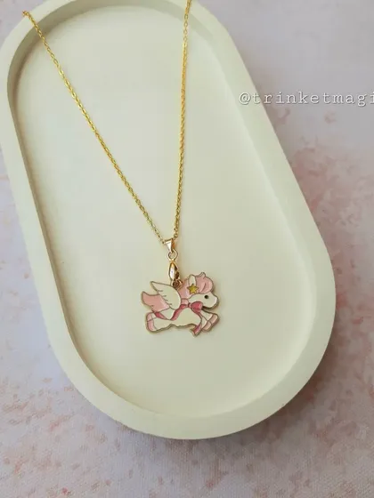 A pink winged unicorn, or pegasus, necklace for the little one who loves fairytales. The soft pink color and star detail make it extra special.