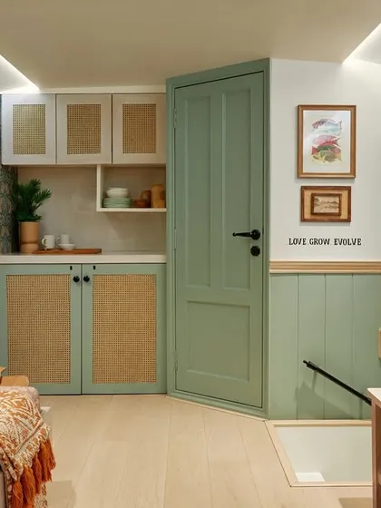 This view shows the functional core of the vanity van, where every inch is optimized for heavy use. The sage green paneling and rattan cabinetry house a full pantry with a fridge, induction cooktop, and microwave, all securely bolted. Adjacent to this, a discreetly placed door leads to a small washroom for the team, demonstrating how I integrate essential utilities without compromising the design's clean, calm aesthetic.