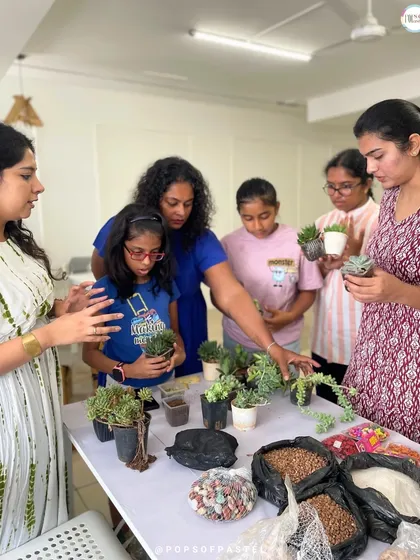 Our instructor explains the different types of succulents to a group of enthusiastic learners at a terrarium workshop.