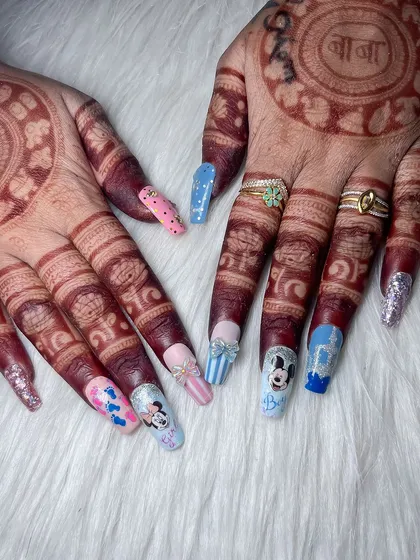 A creative and fun baby shower-themed nail set with Mickey and Minnie Mouse art, done by a student. This shows their ability to handle custom and detailed character designs.