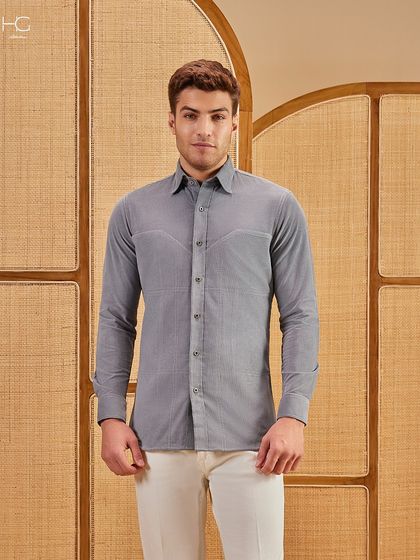 The fine texture of this grey corduroy shirt is evident in this shot. It's a piece that combines the relaxed feel of corduroy with a polished, modern silhouette.