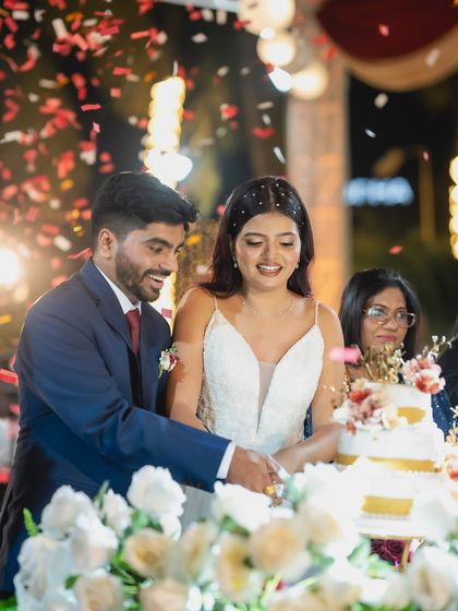 A happy moment during the cake cutting ceremony, with confetti raining down. This photo is full of joy, celebration, and beautiful details.
