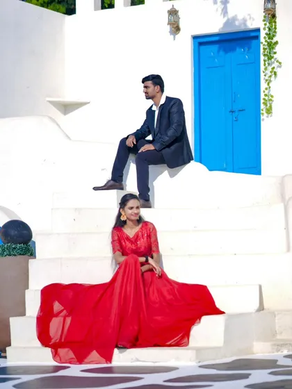 A stylish pose on the steps of our Santorini set. The bride's red gown and the groom's suit create a classic, elegant look.