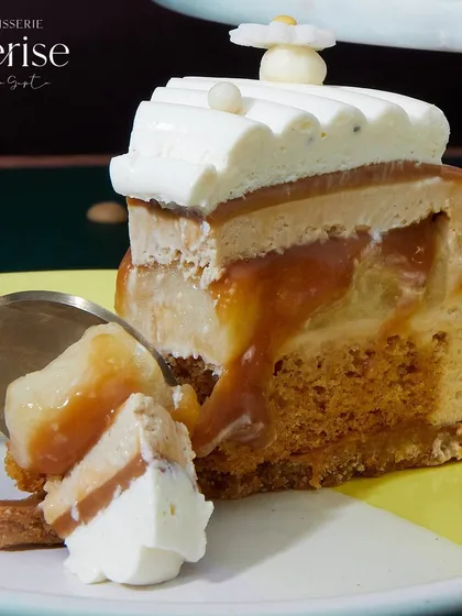 A close-up of a slice of Karamella, showing the gooey caramel and banana layers. It's a dessert that vanishes at midnight.