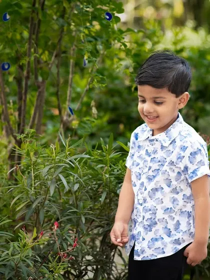 A candid shot of a boy exploring a garden. Outdoor sessions are perfect for capturing a child's sense of wonder.