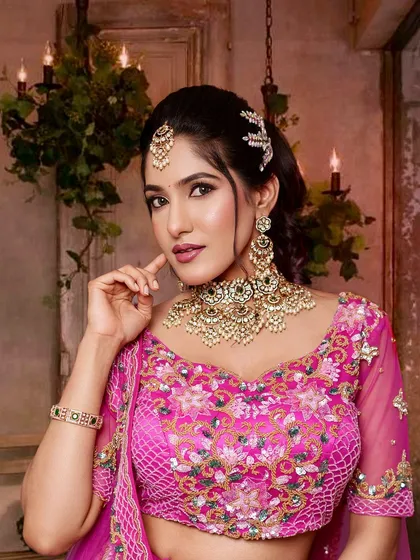 For a modern reception or sangeet, a statement Kundan jewellery set can be absolutely perfect. This gorgeous piece with intricate pearl work beautifully complements the bride's vibrant pink lehenga, creating a look that is both elegant and glamorous.