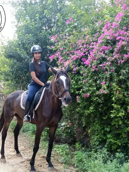 A rider poses with her horse next to a blooming bougainvillea bush. Our trails are full of beautiful flora, adding vibrant color to your riding experience.