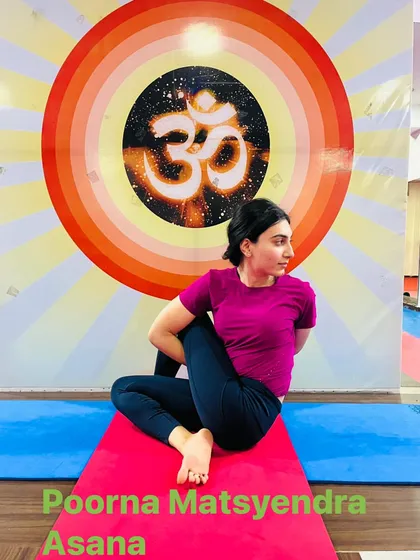 The full expression of the seated spinal twist, Poorna Matsyendrasana. This advanced pose requires significant flexibility in the spine and hips.
