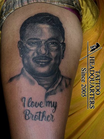 A memorial portrait tattoo on the upper arm with the script "I love my Brother," a heartfelt tribute created with realistic detail.