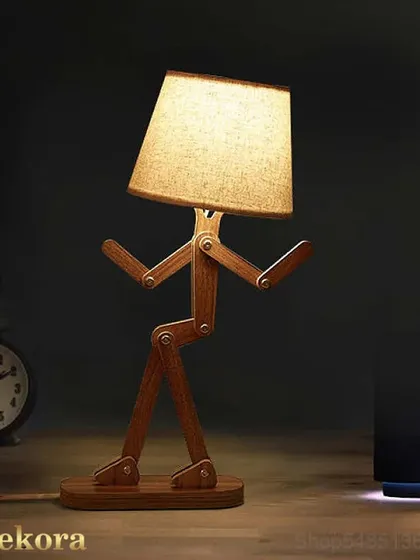 Add a playful and creative touch to any desk or bedside table with our adjustable Wooden Robot Lamp. This quirky piece is handcrafted from wood and can be positioned in various poses, making it a fun and functional lighting accessory.