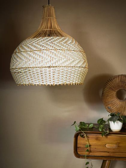 The white and natural pendant, unlit. Its clean color palette and classic shape make it an incredibly versatile piece that can brighten up a kitchen, dining area, or living room.