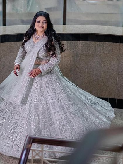 A twirling shot of the client in the silver-grey lehenga, highlighting its beautiful volume.