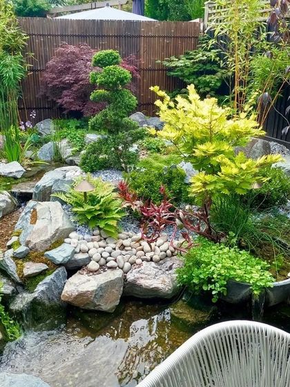 A Japanese-inspired zen garden. This design uses a combination of carefully placed rocks, pebbles, a small water feature, and sculpted plants like Japanese maples and bamboo to create a space of calm and tranquility.