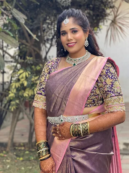 Our client Gagana looks stunning in a diamond and emerald CZ set. The choker, matching earrings, and vaddanam (waist belt) create a complete and elegant look for her special day.