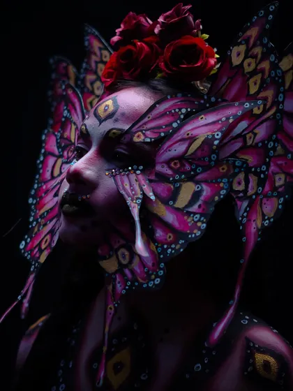 The dark, moody lighting in this shot adds a dramatic and mysterious element to the butterfly look.