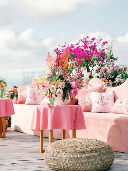 The 'Villa Brissa' Mehendi in Bali, an attempt to transport guests to a land of tranquility. This lounge area features rattan furniture and a vivid tapestry of quirky prints against a lush backdrop.