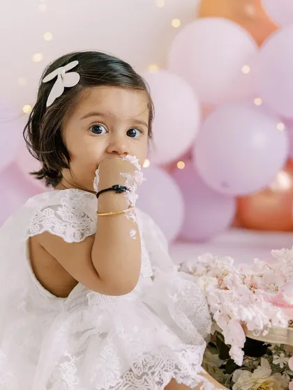 A moment of hesitation before diving into the cake. Her curious look is just as precious as the messy photos that follow.