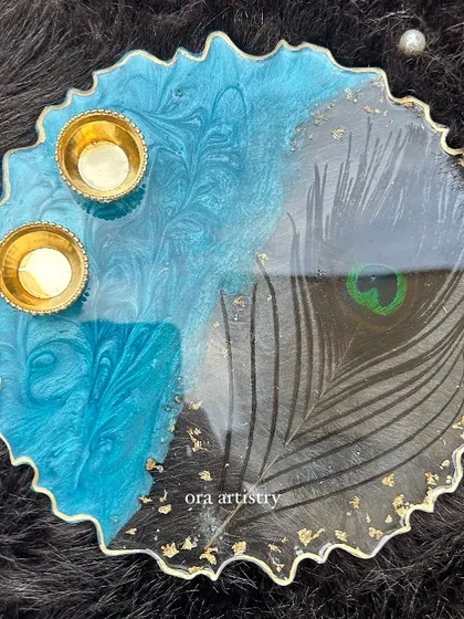 A stunning top-down view of the peacock feather resin platter, complete with holders for small candles or diyas.
