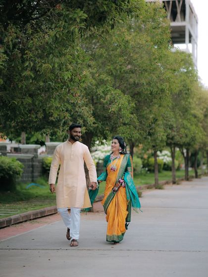 A simple, sweet moment of a couple walking hand-in-hand during their Haldi ceremony. The bride's yellow and green saree perfectly complements the natural surroundings.