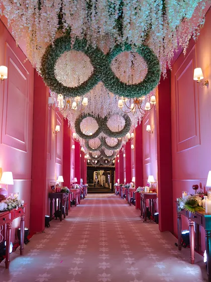 The guest's journey begins the moment they arrive. I designed this dramatic entryway with cascading floral installations and repeating infinity symbols made of lush greenery, creating an immersive and luxurious welcome for a grand reception.