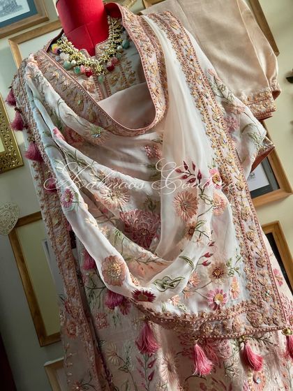 A side view of the styled suit, highlighting the tassels on the dupatta.