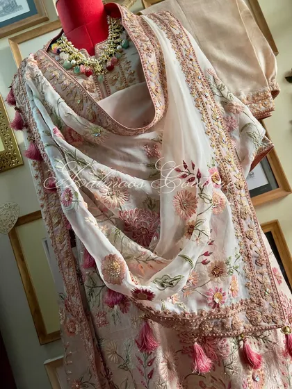 A side view of the styled suit, highlighting the tassels on the dupatta.
