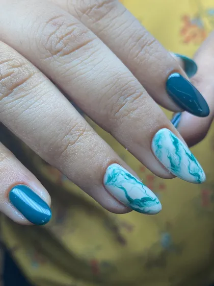 The combination of solid teal and marble accent nails is so chic.