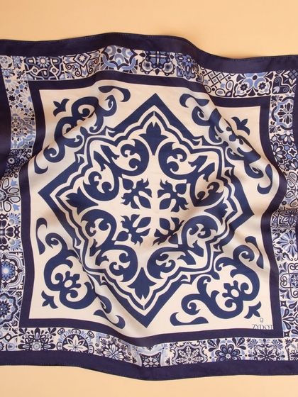 A draped shot of the tile-patterned pocket square, showing the soft folds of the fabric.