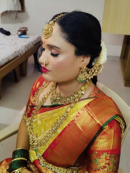 Our happy client Usha, ready for her big day. She is wearing a complete antique-finish bridal set, including a choker, long necklace, jhumkas, and a traditional maang tikka that beautifully frames her face.