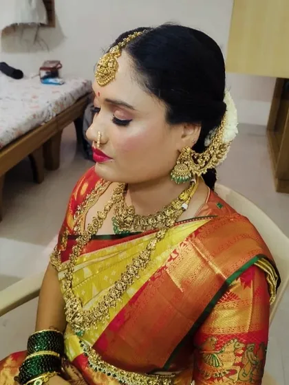 Our happy client Usha, ready for her big day. She is wearing a complete antique-finish bridal set, including a choker, long necklace, jhumkas, and a traditional maang tikka that beautifully frames her face.